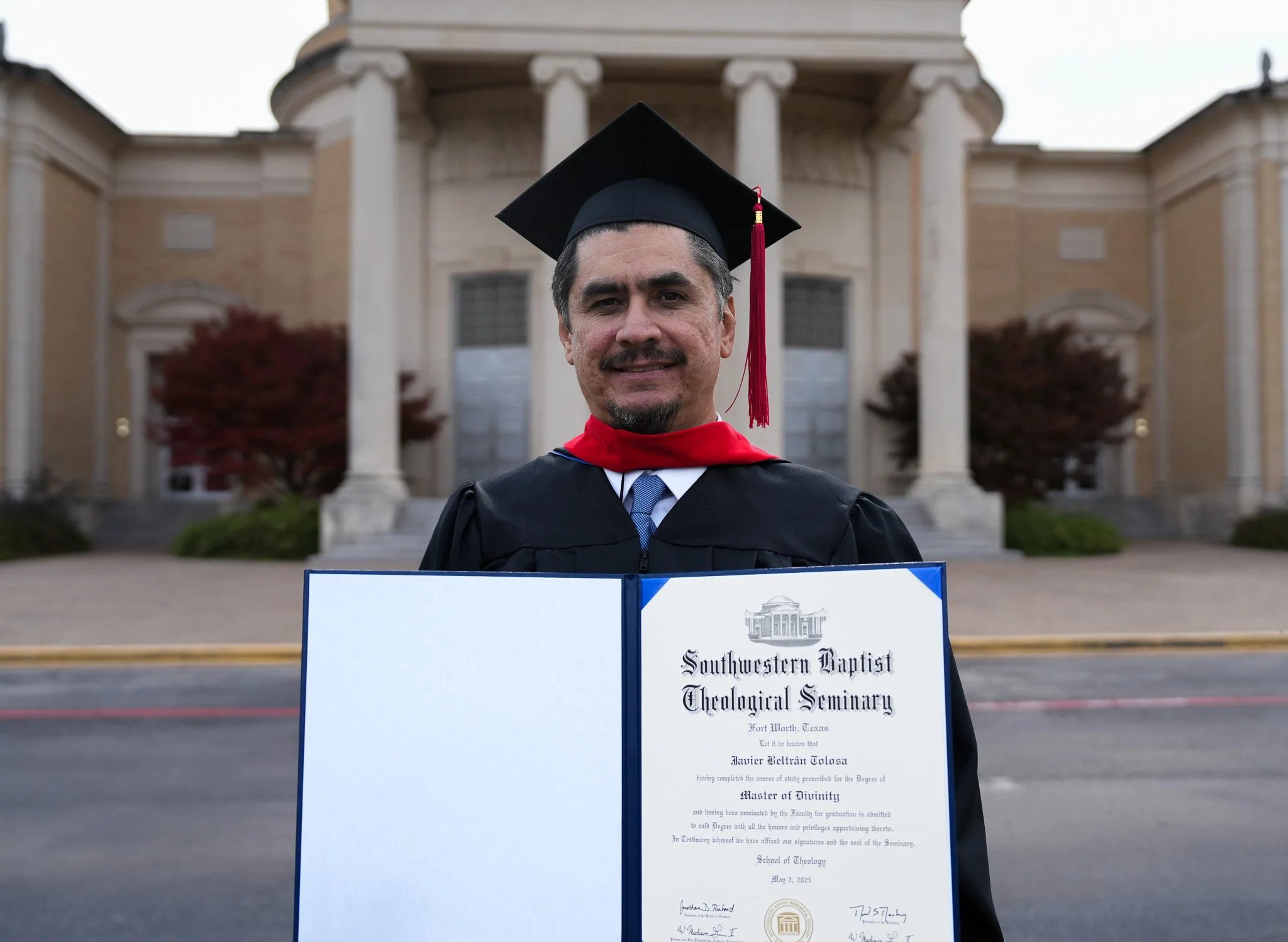Graduate holding diploma in cap and gown