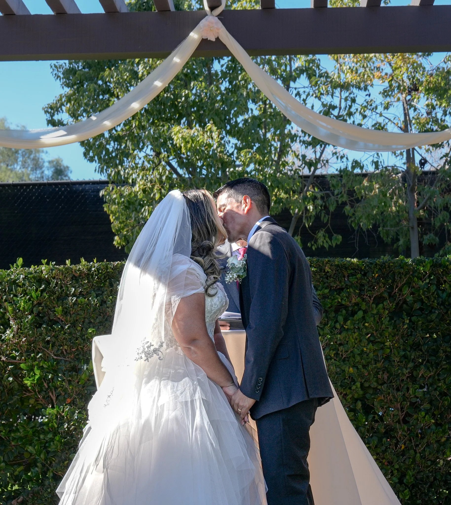Bride and groom share a kiss during the ceremony