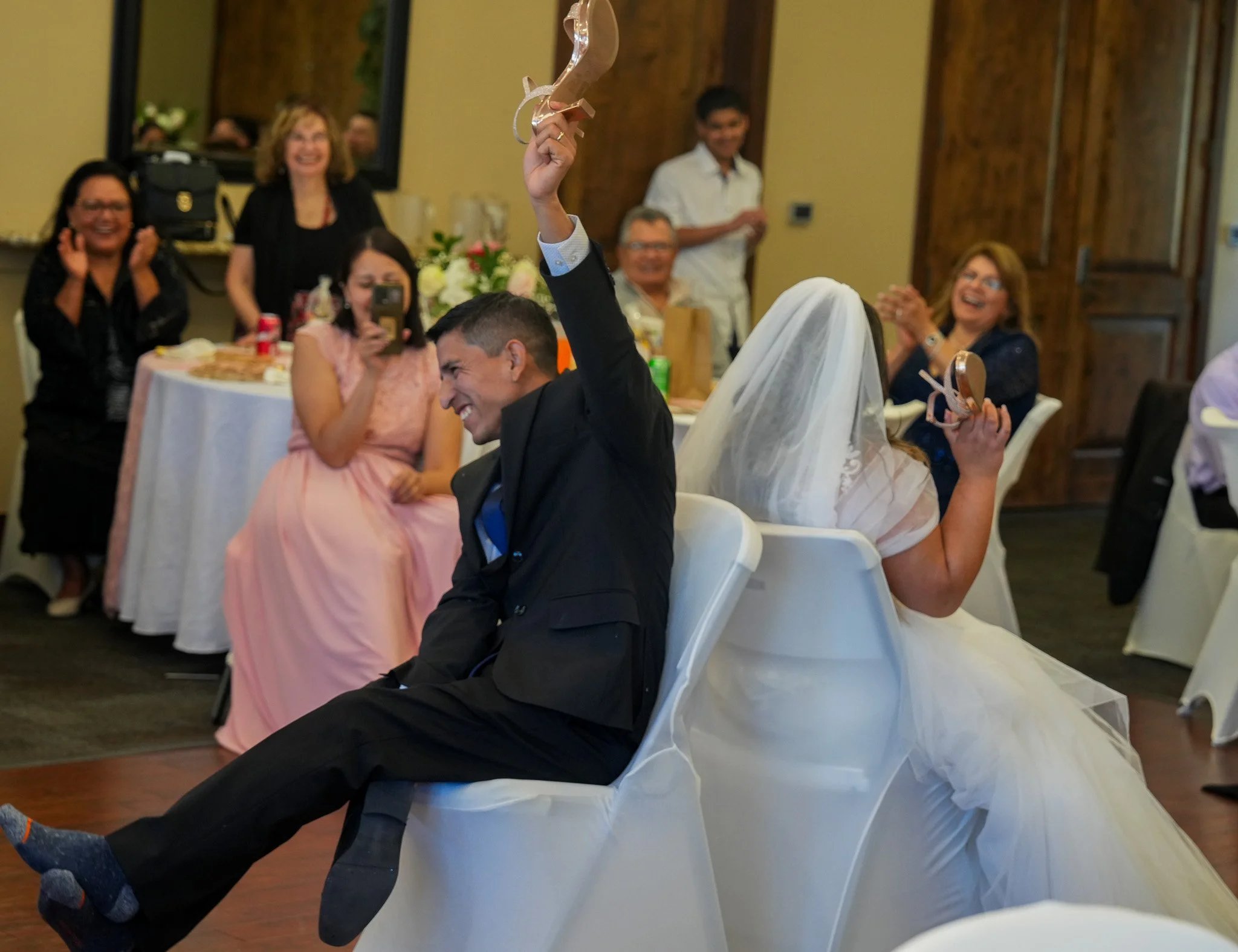 Bride and groom laughing back-to-back at the reception