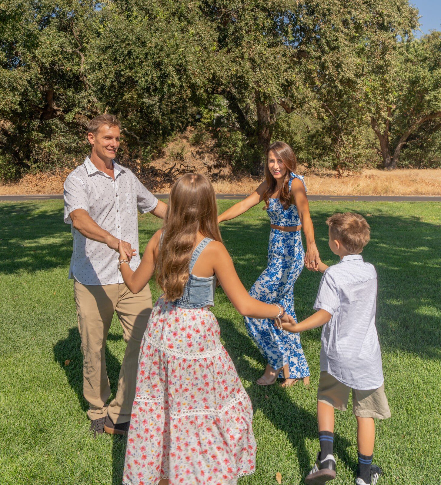 Family circling and holding hands in bright afternoon light