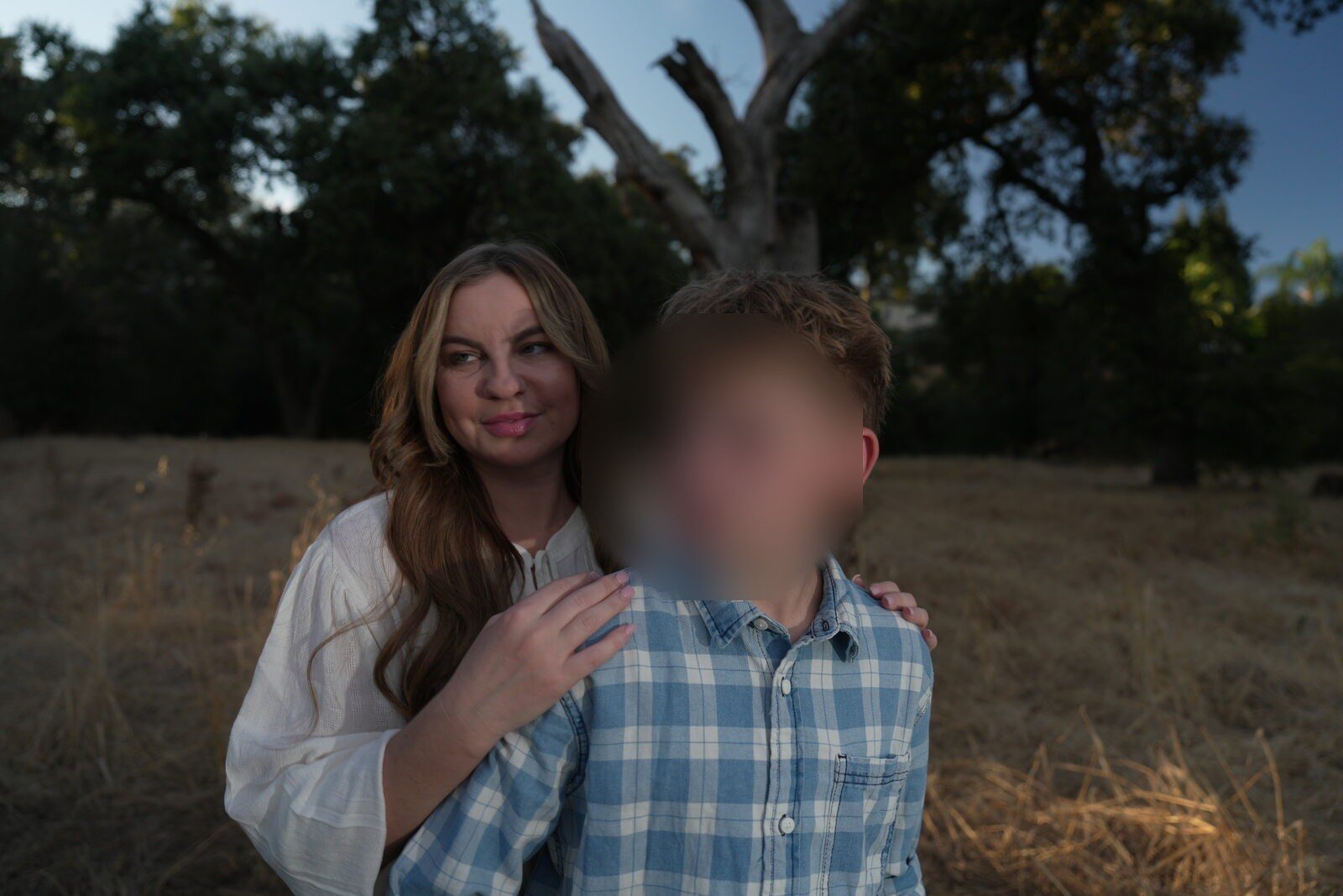 A mother and her son, heads tilted together