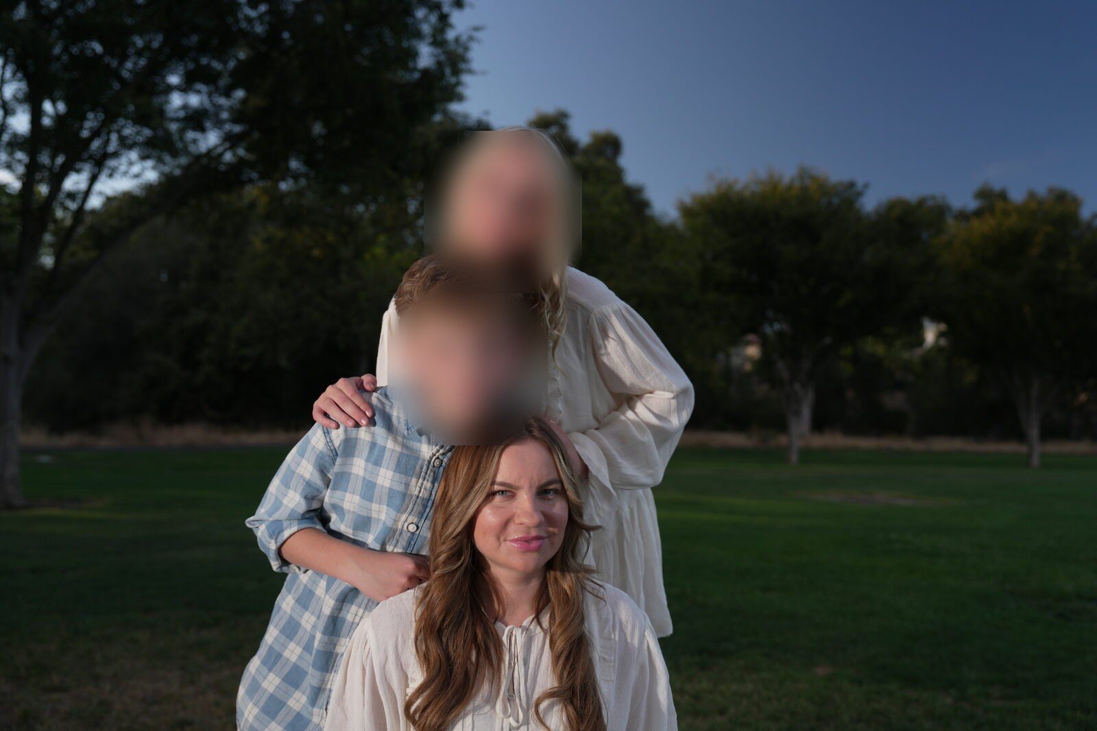 Mother with her arms around two of her children