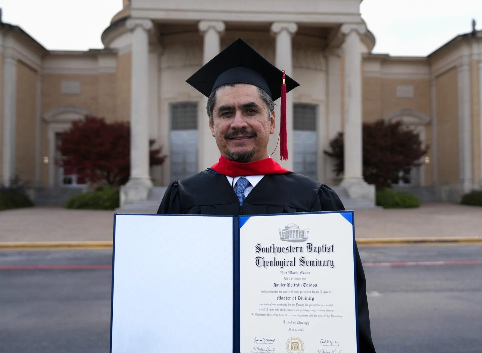 Graduate holding diploma in cap and gown